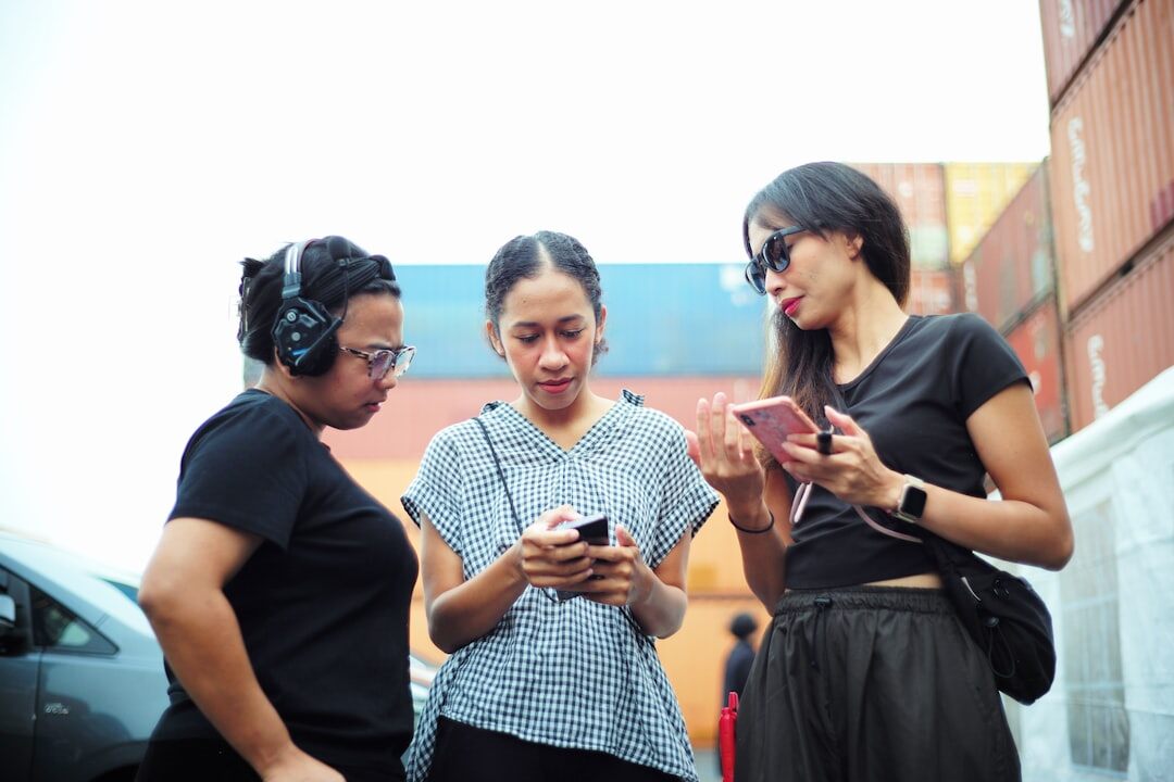 Three colleagues reviewing gadgets and discussing tech news together