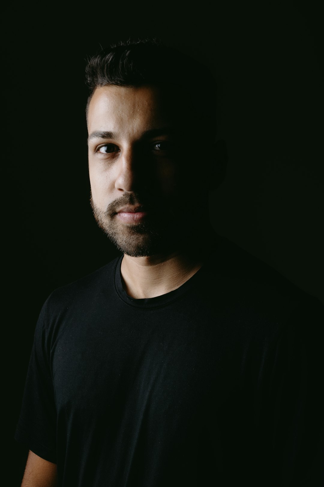 Studio portrait of a man with dark hair and a light beard