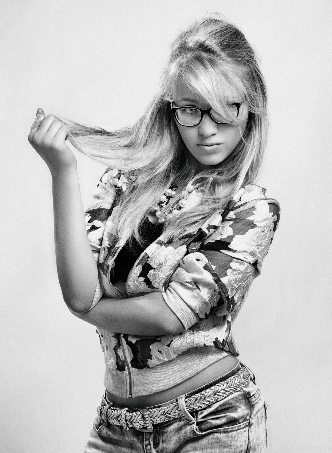 Studio portrait of a young woman with blonde hair and glasses
